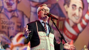 Jürgen Beckers auf der Bühne hinterm Mikrofon