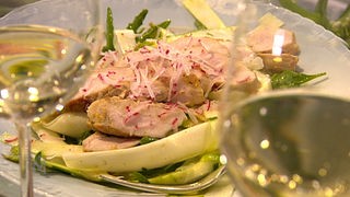 Salat aus rohem Spargel mit Kaninchenrücken auf einem Teller angerichtet