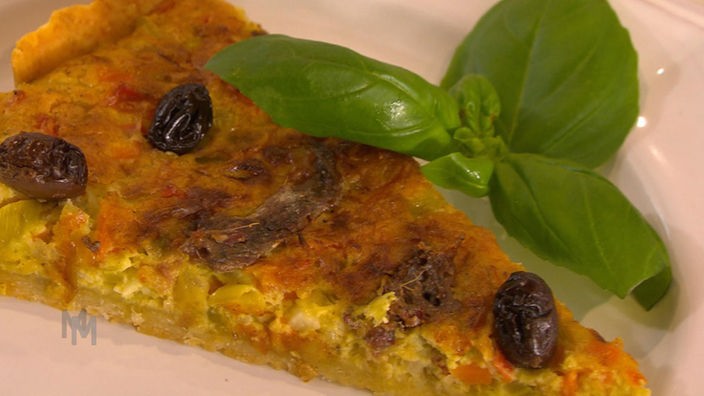 Ein Stück Kuchen mit Oliven und Basilikum garniert