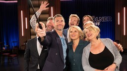 Eine Gruppe von menschen fotografiert sich mit einem Selfiestick
