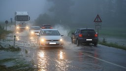Autos fahren über eine völlig überflutete Straße
