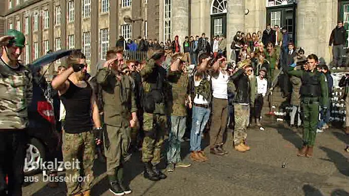 Schüler salutieren verkleidet vor der Schule