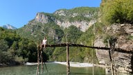 Landschaft in Albanien, im Vordergrund ein See, im Hintergrund die Berge