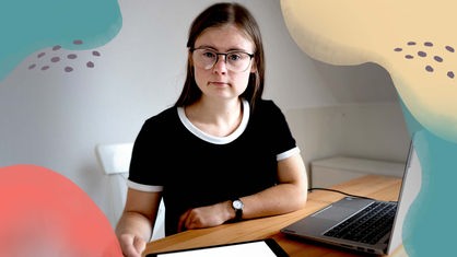 Eine junge Frau mit Down-Syndrom am Schreibtisch