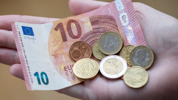 Das Bild zeigt Spargel Geld in einer geöffneten Hand.