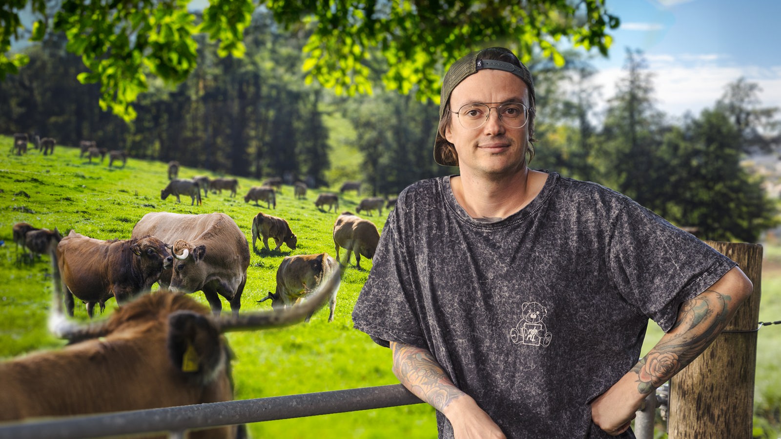Betriebsleiter Mark Junglas vor einer Weide mit Kühen.