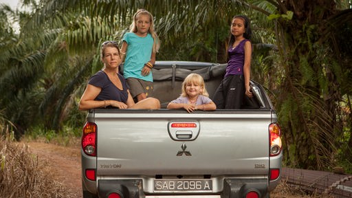 Eine Mutter mit drei Mädchen auf der Ladefläche eines Pick Up Trucks