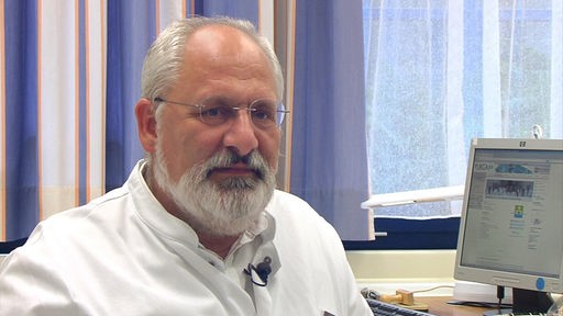 Prof. Jürgen Schäfer sitzt am Schreibtisch.