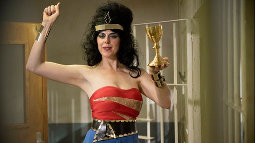 Eine Frau ist als eine Mischung aus Ägypterin, Amy Winehouse und Superwoman verkleidet