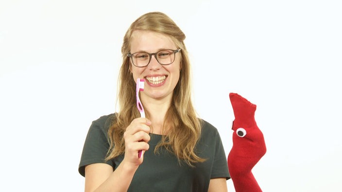 Esther zeigt Socke ihre Zahnbürste