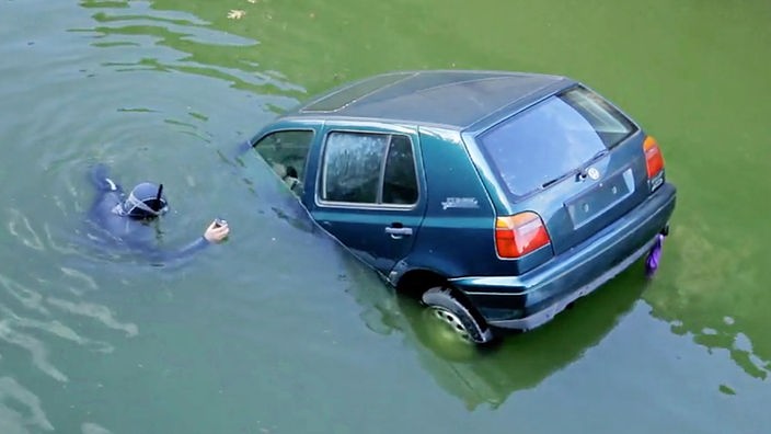 Ein Auto geht im Wasser unter. 