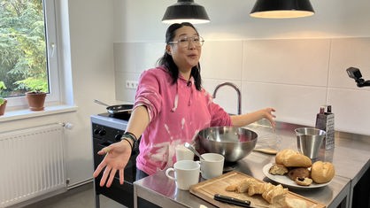 Shia Su in einer Küche bei den Vorbereitungen für ein leckeres Frühstück.