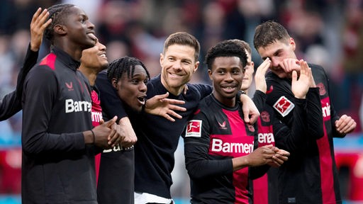  Leverkusens Trainer Xabi Alonso (M) feiert nach der Partie mit den Spielern