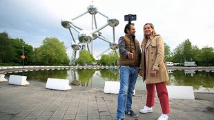 Dsa Bild zeigt Tamina Kallert und ihren Kameramann Uwe Irnsinger vor dem Atomium in Brüssel.
