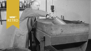 Ein Mann steht an einer Maschine um Schnupftabak herzustellen 