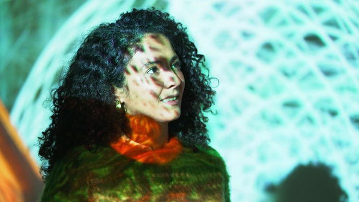 Westart-Moderatorin Siham El-Maimouni im Schwebodrom, angestrahlt von einer Lichtinstallation