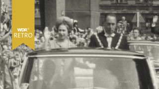 Queen Elizabeth begrüßt Menschen in Köln aus dem fahrenden Auto