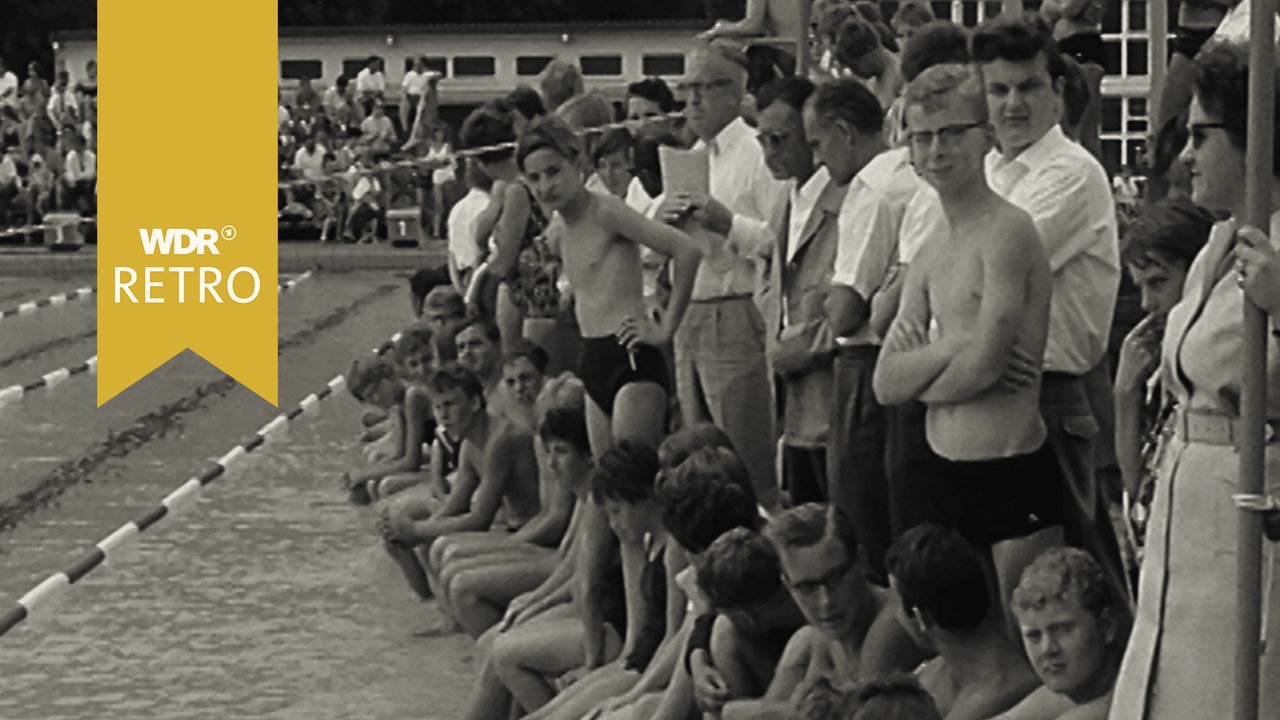 Ein Publikum neben einem Freibad-Schwimmbecken