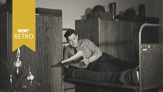 Ein Mann liegt auf einem Bett und liest eine Zeitung