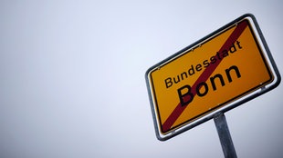 Durchgestrichenes Schild mit der Aufschrift "Bundesstadt Bonn"