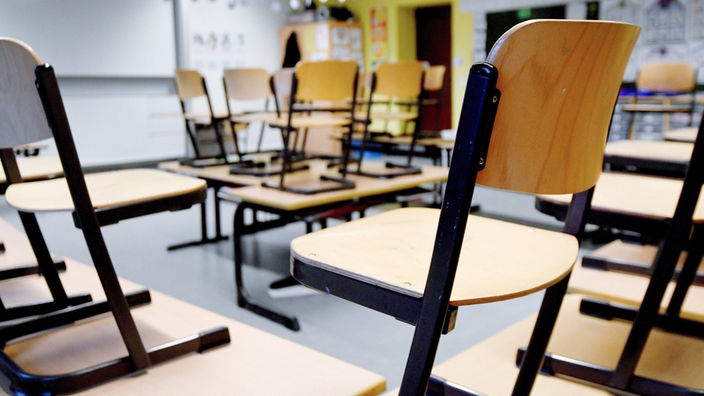 Stühle stehen in einem Klassenzimmer in einer Grundschule auf den Tischen