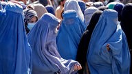 Frauen in Burkas warten auf Lebensmittelrationen, die von einer humanitären Hilfsorganisation aus Saudi-Arabien verteilt werden