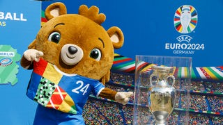 UEFA EURO 2024: Maskottchen Albärt neben dem EM Pokal