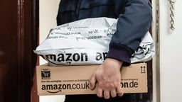 Paketbote übergibt zwei Amazon Pakete