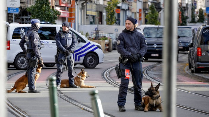 Belgische Polizisten mit Hunden riegeln eine Straße in Brüssel ab