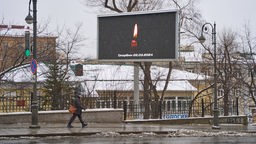 Eine Anzeigetafel zeigt auf der Straße eine Kerze zum Gedenken an die Opfer des Anschlags in Moskau