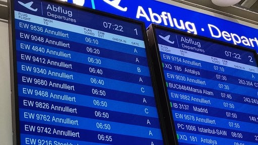 Bildschirme am Düsseldorfer Flughafen, der die gestrichenen Flüge anzeigen.