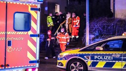 Polizei und Krankenwagen stehen vor einem Haus nach einer Attacke in Hagen nach einer Trennung.