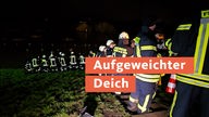Einsatzkräfte der Feuerwehr bilden eine Kette an der Ruhr