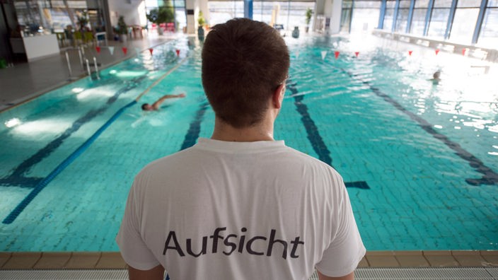 Ein Bademeister steht am 21.01.2016 in einem Hallenbad in Stuttgart vor einem Schwimmbecken.