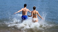 Ein Mann und eine Frau laufen ins Wasser