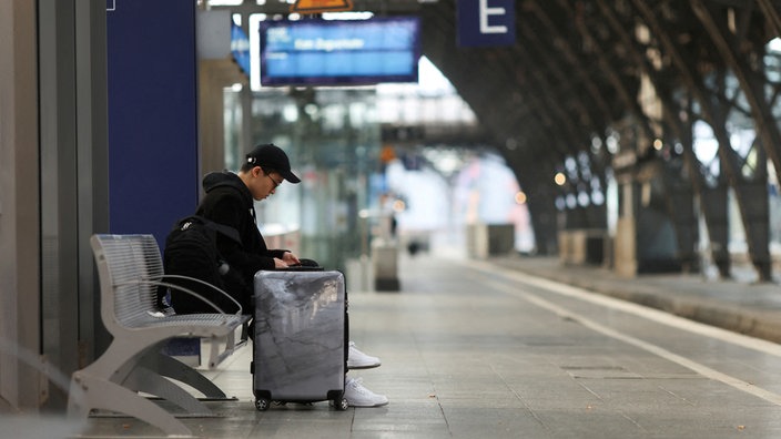 Reisender wartet an einem leeren Gleis