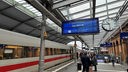 Menschen stehen am Gleis am Bahnhof Bonn, ein ICE steht bereit zur Abfahrt