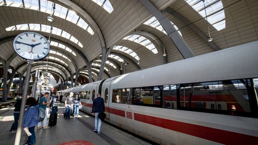 Eine Uhr am Bahnsteig des Kieler Hauptbahnhofes, rechts davon steht ein ICE