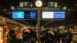 Reisende steigen am Bahnsteig des Hauptbahnhofs aus einem Regionalzug.