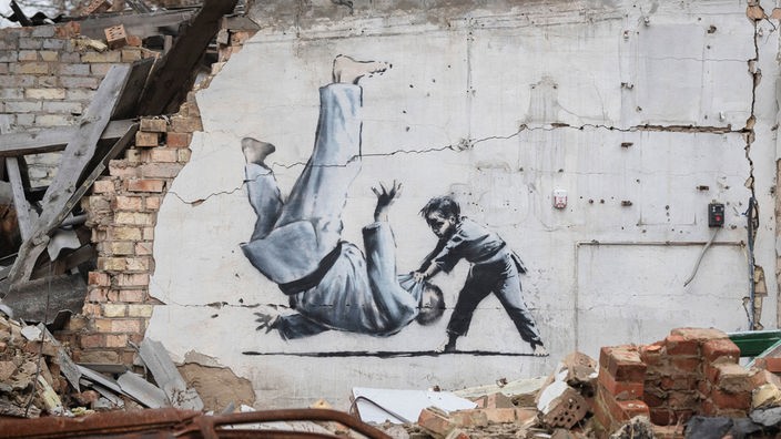 Banksy-Graffiti auf zerstörtem Gebäude