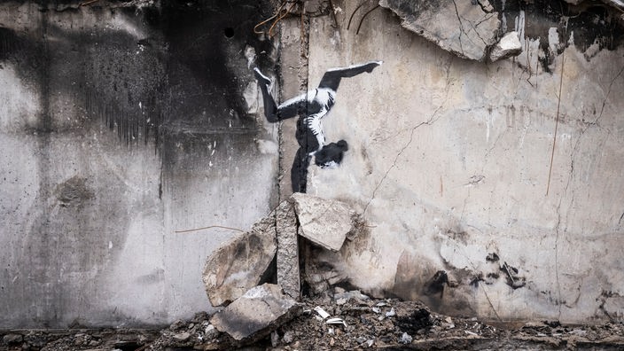 Bild eines Mädchens, das Handstand macht, auf einer kaputten Mauer