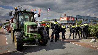 Landwirte blockieren eine Filiale der Supermarktkette Boni mit Traktoren