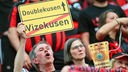 Ein Fan von Leverkusen hält bei der Meisterfeier in der BayArena ein Schild hoch
