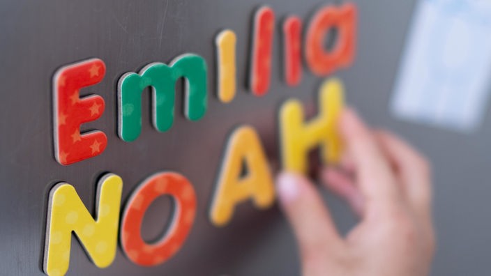 Noah und Emilia mit Magnetbuchstaben an einer Tafel