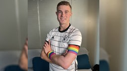 Bengt Kunkel zeigt sich solidarisch im Deutschlandtrikot und Kapitänsbinden in Farben der Pride-Flag