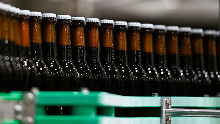 Bierflaschen auf einem Fließband in einer Brauerei.