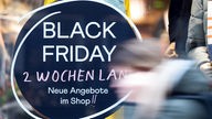 Köln: Eine Frau geht an einem Geschäft vorbei, das mit Black Friday-Angeboten wirbt