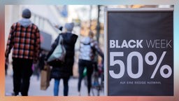 Auf einem Aufsteller vor einem Geschäft in Köln steht "Black Week 50%" 