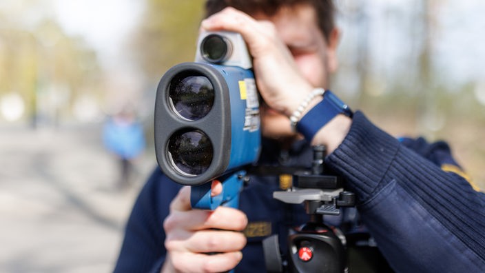 Polizist hält eine Laserpistole