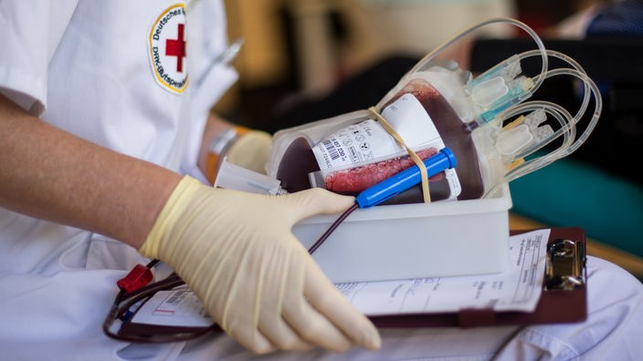 Eine Krankenschwester hält eine Blutspende